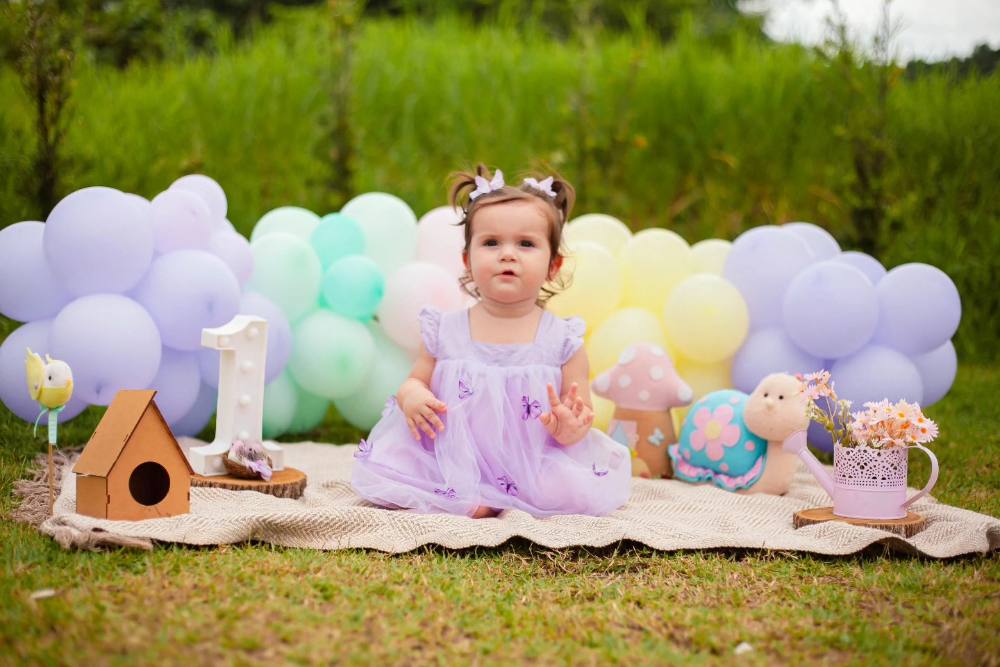 Bebê de 1 ano em cenário decorado com balões para ensaio smash the cake