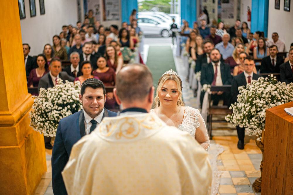 Cerimônia de casamento na igreja com os noivos diante do altar