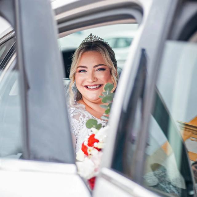 Noiva sorrindo na janela do carro no dia do casamento
