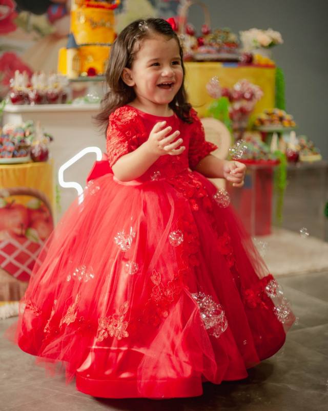 Menina em vestido de festa sorrindo na comemoração